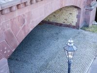a brick bridge with two old lamps and an ornately decorated design on the side of the bridge
