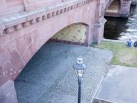 a brick bridge with two old lamps and an ornately decorated design on the side of the bridge