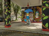 a building that has some murals on it and a fire hydrant in the foreground