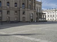 the person riding on a bicycle in front of an old building with a blue flag