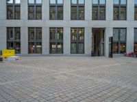 a courtyard with a building on the other side and a large white building with many windows