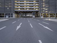 a deserted road going through a large building and into the parking garages at the same time