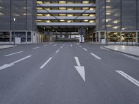 a deserted road going through a large building and into the parking garages at the same time