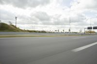 a photo taken of an empty road with a car on it and clouds above the road