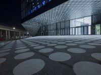 the exterior of an art museum at night in the dark with a big circular pattern on the floor