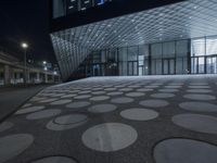 the exterior of an art museum at night in the dark with a big circular pattern on the floor