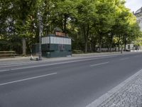 street with road near park and building in city area with trees on either side of it