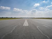 the sky is a blue and cloudy sky behind the clouds above an airport runway with white lines on it