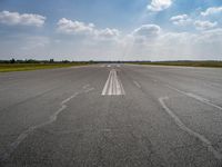 the sky is a blue and cloudy sky behind the clouds above an airport runway with white lines on it