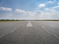 the sky is a blue and cloudy sky behind the clouds above an airport runway with white lines on it