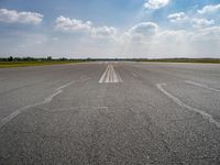 the sky is a blue and cloudy sky behind the clouds above an airport runway with white lines on it