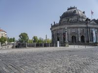 a dome building with a large stone walkway in front of it and a walkway near the entrance