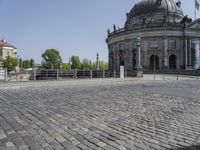 a dome building with a large stone walkway in front of it and a walkway near the entrance