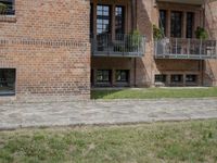 brick building with balcony and balconies on the side of it in an open field