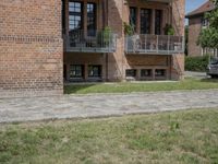 brick building with balcony and balconies on the side of it in an open field