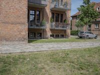 brick building with balcony and balconies on the side of it in an open field