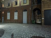 brick courtyard next to a building with old door way signs on the front of the building