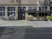 a brick street area with a bench, benches and many bikes parked in it's shadow