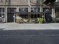 a brick street area with a bench, benches and many bikes parked in it's shadow