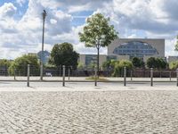 a man sitting on a skateboard in the middle of a brick street next to trees