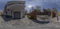 360 - view of two buildings with multiple parking spaces in them on the bricked street