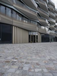 a brick paved patio and walkway with an office building in the background in london, england