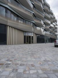 a brick paved patio and walkway with an office building in the background in london, england