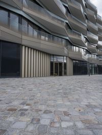 a brick paved patio and walkway with an office building in the background in london, england