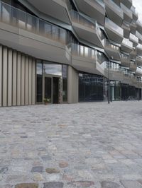 a brick paved patio and walkway with an office building in the background in london, england