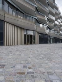 a brick paved patio and walkway with an office building in the background in london, england