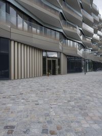 a brick paved patio and walkway with an office building in the background in london, england
