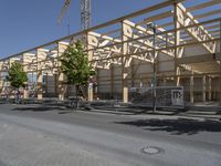 an empty street in front of a building under construction on the same side of a road