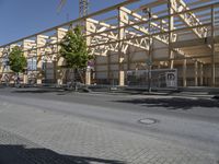 an empty street in front of a building under construction on the same side of a road