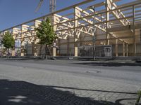 an empty street in front of a building under construction on the same side of a road