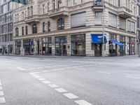 a building in the middle of a street and an intersection with traffic signal lights in view