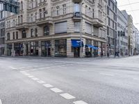 a building in the middle of a street and an intersection with traffic signal lights in view