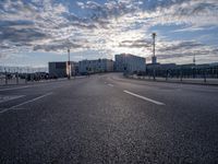 an empty highway leading into the sunset on a cloudy day with lots of cars driving past