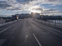 an empty highway leading into the sunset on a cloudy day with lots of cars driving past