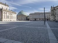 square with a church in front of the building and several other large buildings across from it