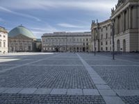 square with a church in front of the building and several other large buildings across from it