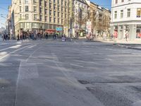 the people are waiting to cross the street from the tram station to the sidewalks