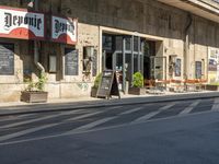 a cafe sitting on the side of a street in a city with no cars or buses