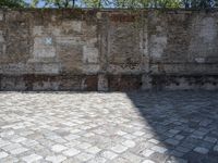 a picture of brick floor and walls and one large bench with red fire hydrant