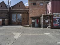 two brown buildings sit in front of a brick building with two smaller windows and no one standing at the door