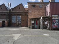 two brown buildings sit in front of a brick building with two smaller windows and no one standing at the door