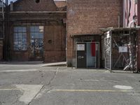 two brown buildings sit in front of a brick building with two smaller windows and no one standing at the door