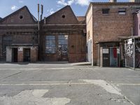 two brown buildings sit in front of a brick building with two smaller windows and no one standing at the door