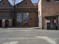 two brown buildings sit in front of a brick building with two smaller windows and no one standing at the door