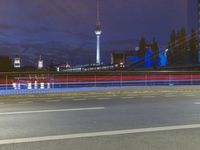 the skyline of berlin, germany is visible behind an empty street in this image, there's a bridge and tall buildings