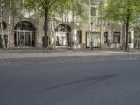 there is an empty street in the city with tall buildings in the background and a street light to the side